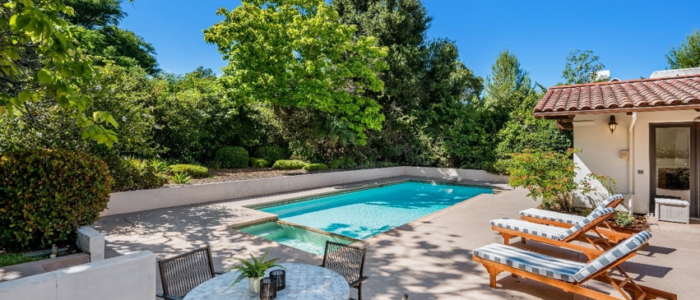 backyard outdoor pool with table and pool chairs